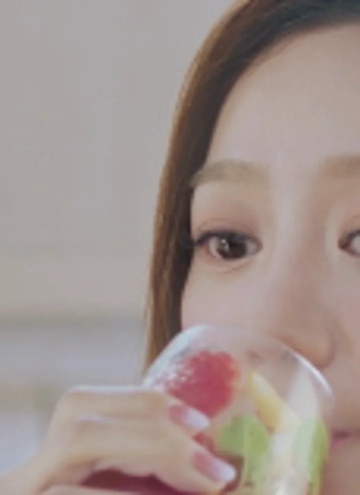 A frame of Wells The One at 640 by 360, enlarged: soft eyelashes and glass, beside the same frame after an AI upscale to 4K